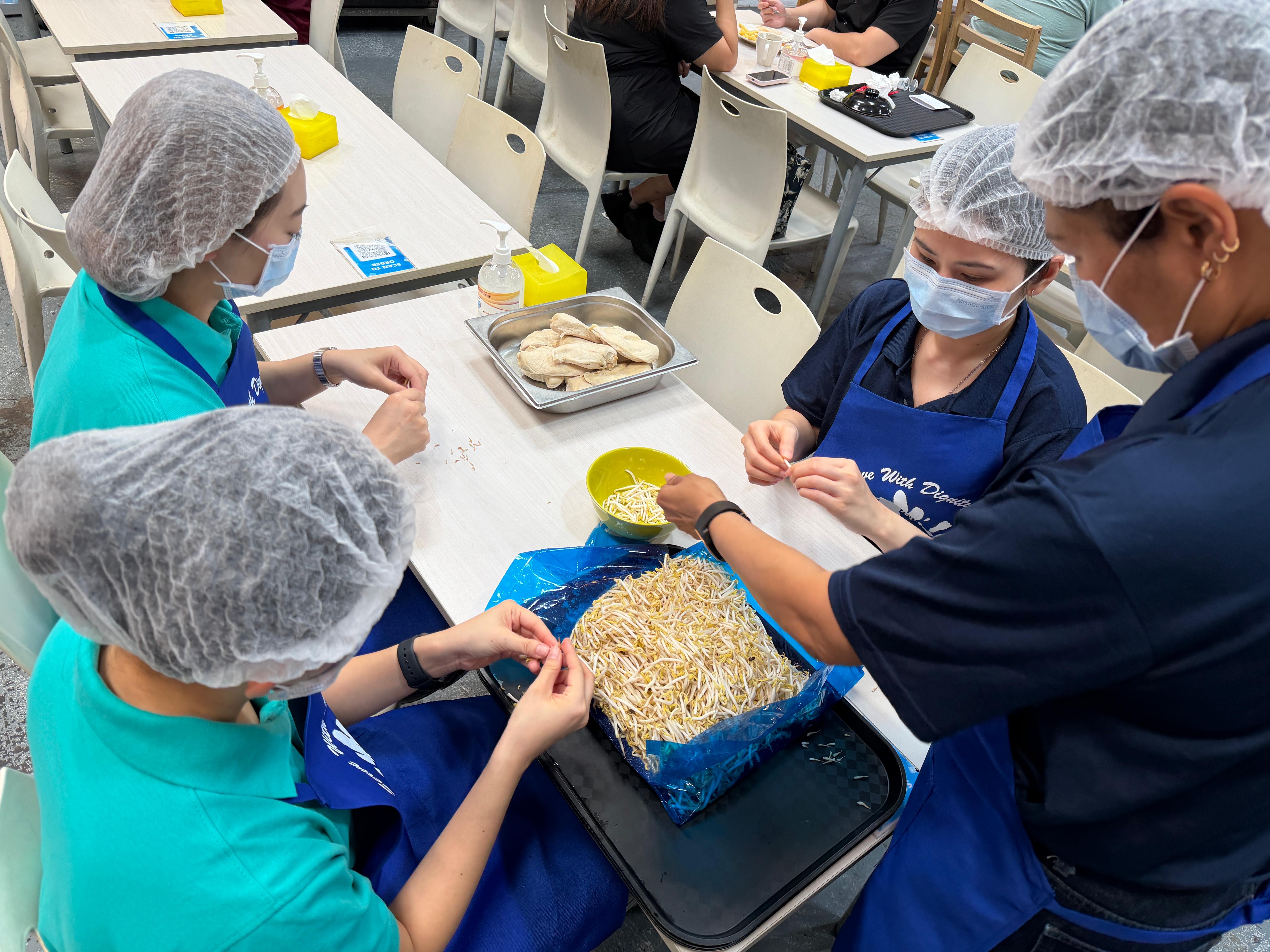 Another angle from above the group of TD SYNNEX Singapore DEI committee volunteers working together around a table at Dignity Kitchen during Project Dignity.