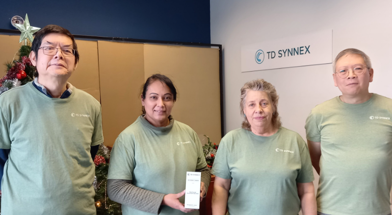 Gary Wong and several of his TD SYNNEX co-workers take a team photo together holding their shared TD SYNNEX 2025 Sustainability Awards trophy.